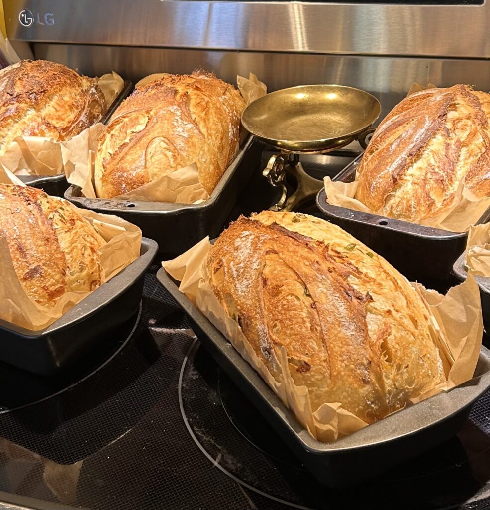 Loaves of sourdough bread fresh out of the oven with warm lighting.