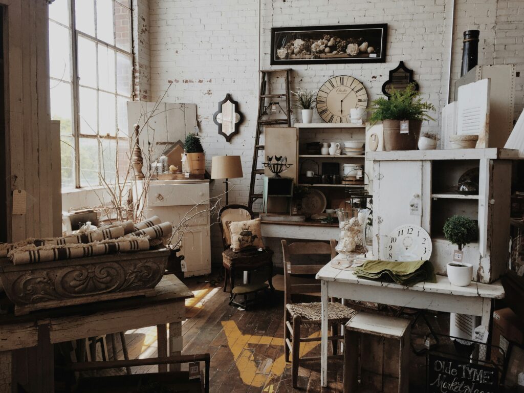 Collection of vintage thrifted home décor items, including wooden furniture, ceramics and blankets.